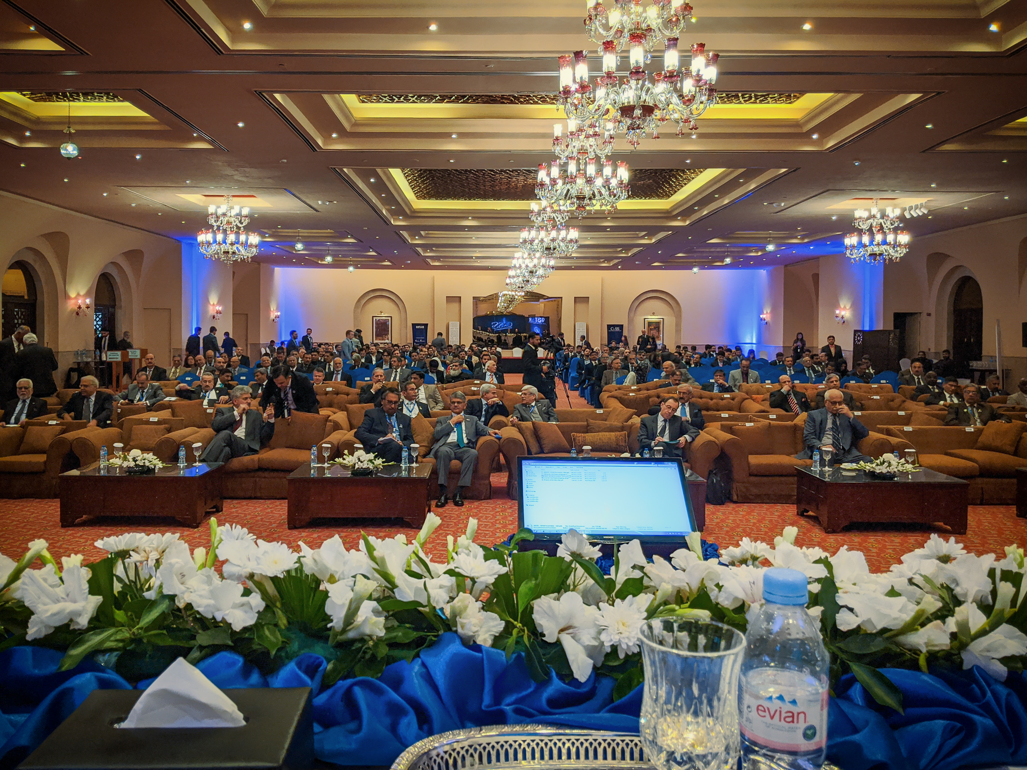 The GSTAR 2020 conference hall photographed by Lyle Holt from the speakers’ table — full international delegation seated beneath chandeliers, the view from the dais