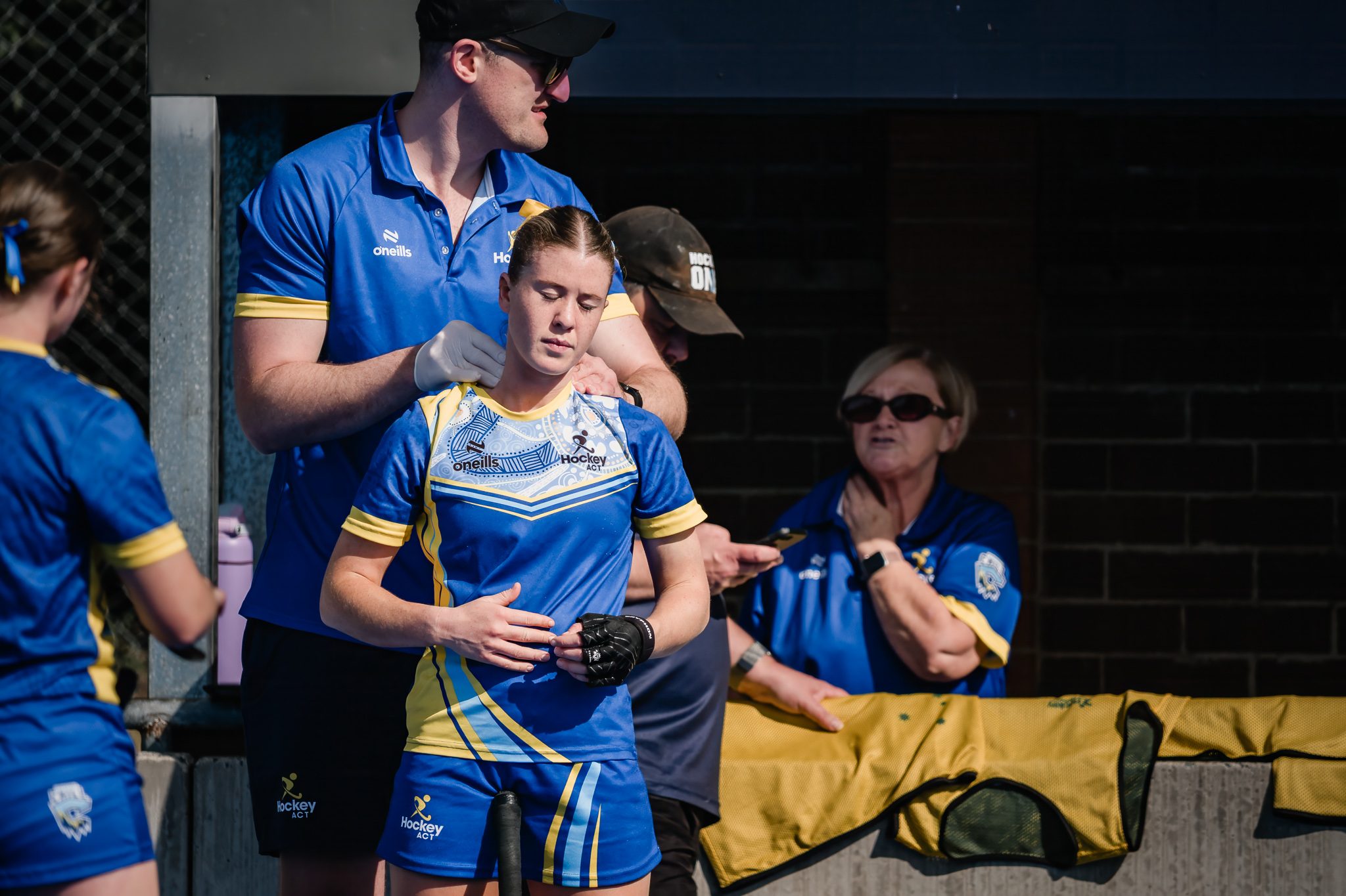Hockey ACT support staff attending to a player on the sideline