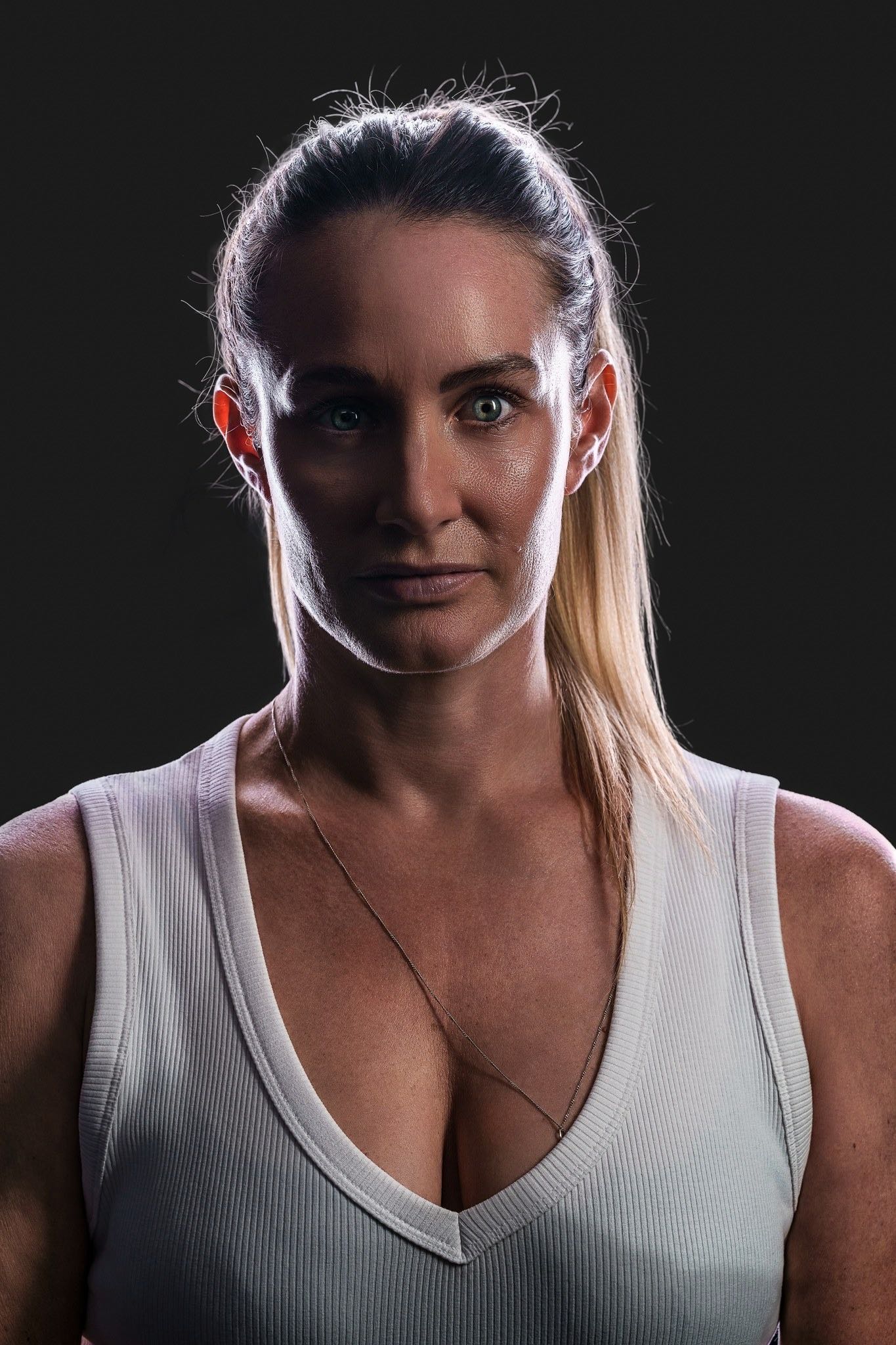 Hockey ACT pathway athlete identity portrait, front-on under dramatic single-source rim lighting