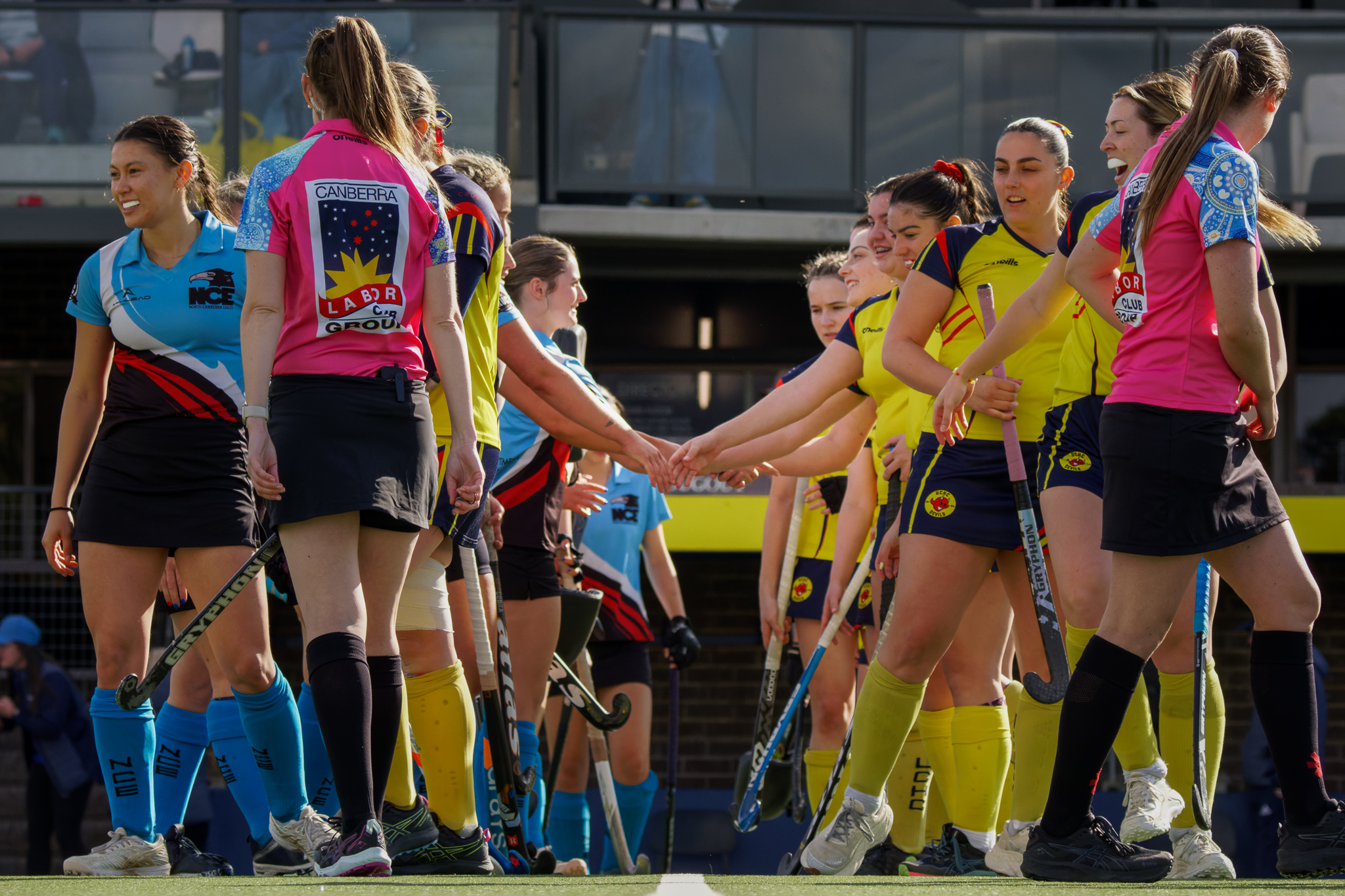 Hockey ACT women's teams pre-match handshake — sportsmanship and community values in action