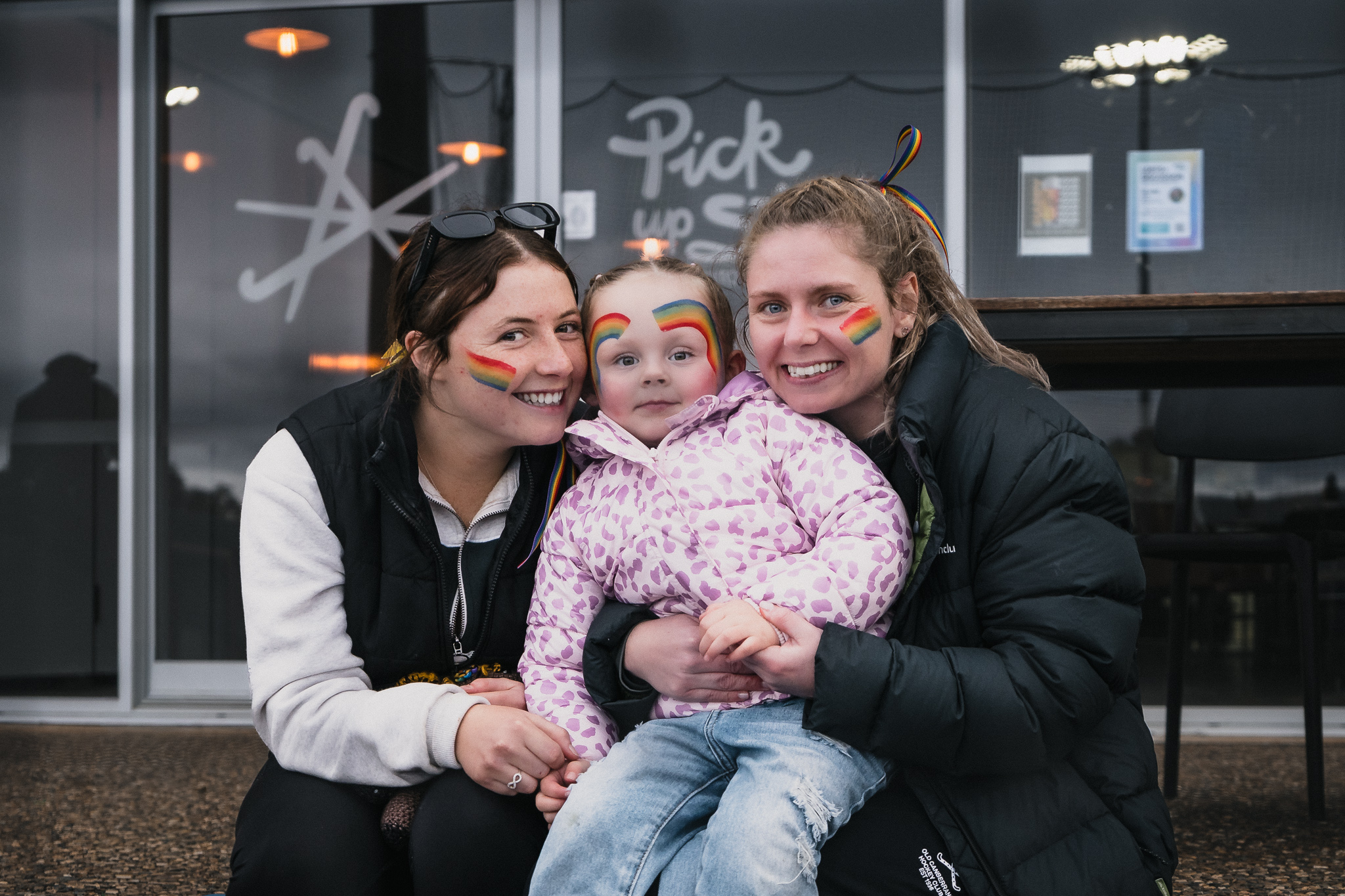 Hockey ACT Pride Round — players and child with rainbow face paint, community engagement