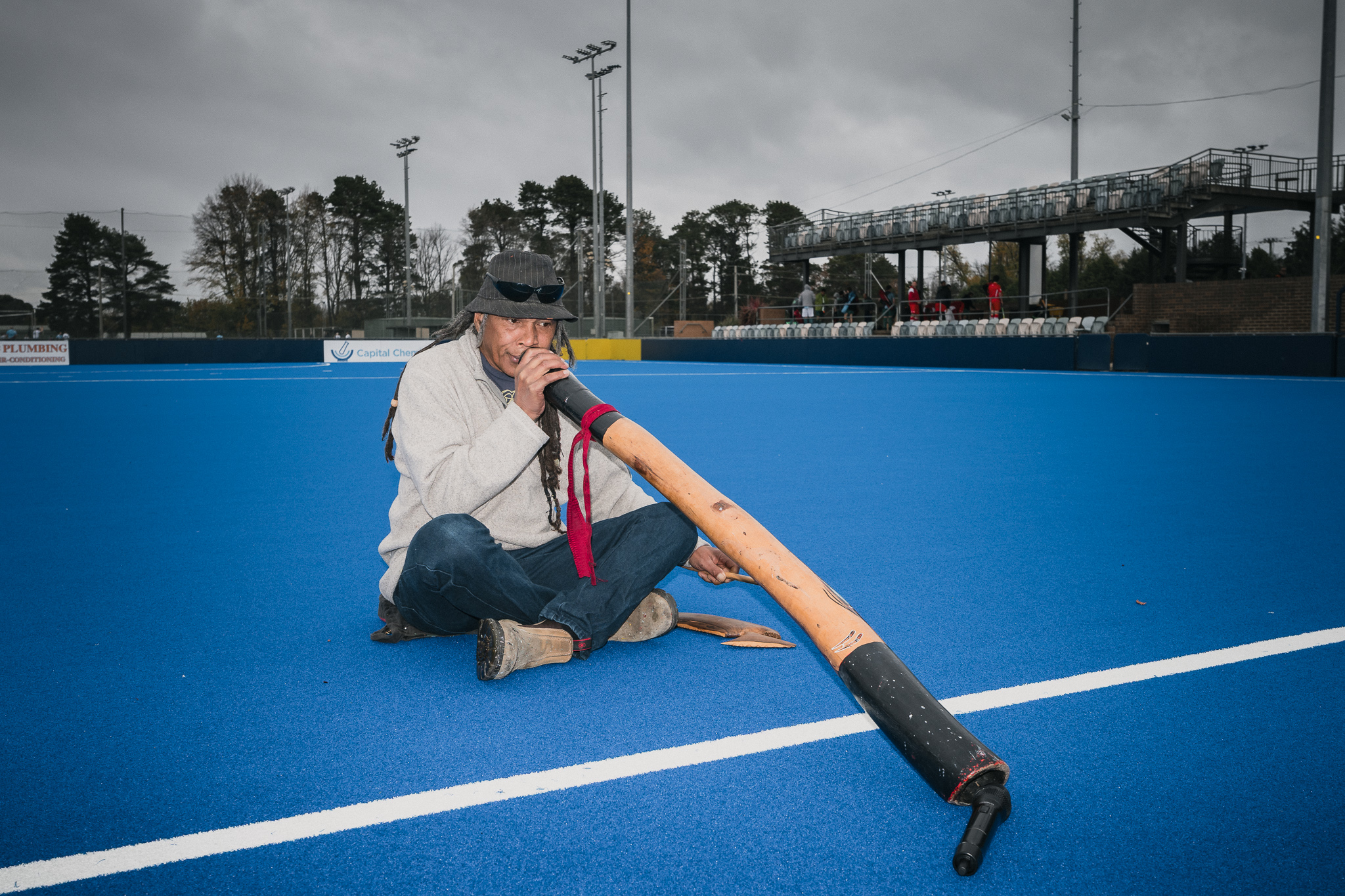 Hockey ACT Reconciliation Round — First Nations musician performing on the pitch with didgeridoo, cultural ceremony documenting programme values
