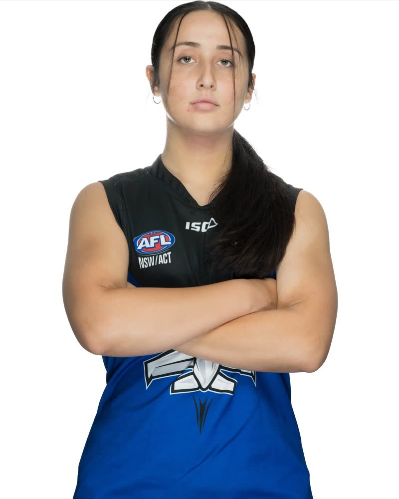 AFL Canberra Media Day studio portrait, player in a blue guernsey with arms folded, on white