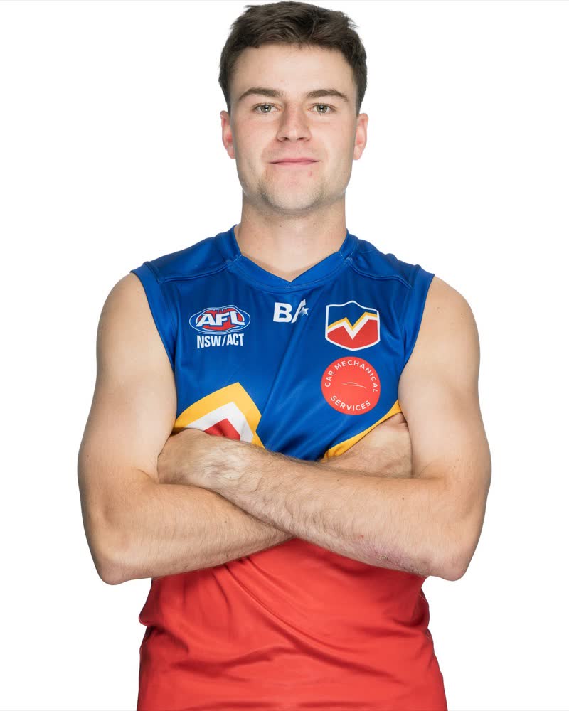 AFL Canberra Media Day studio portrait, controlled lighting on face and sponsor mark