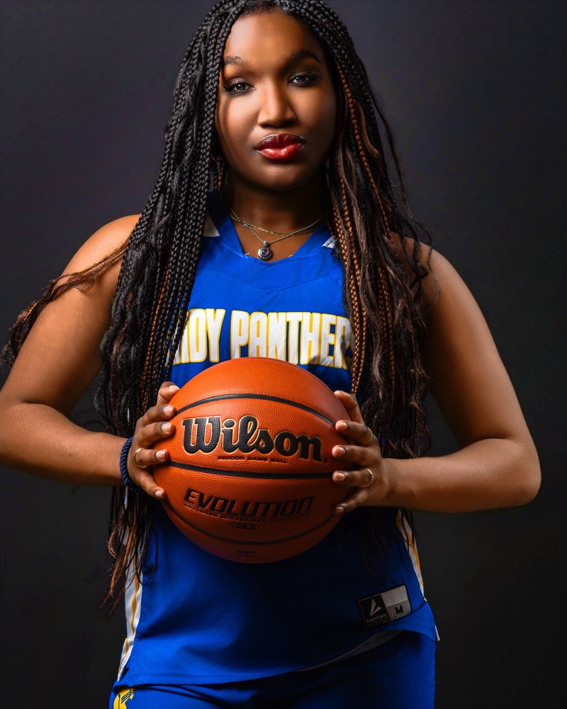 The same basketball player square to camera, holding the ball