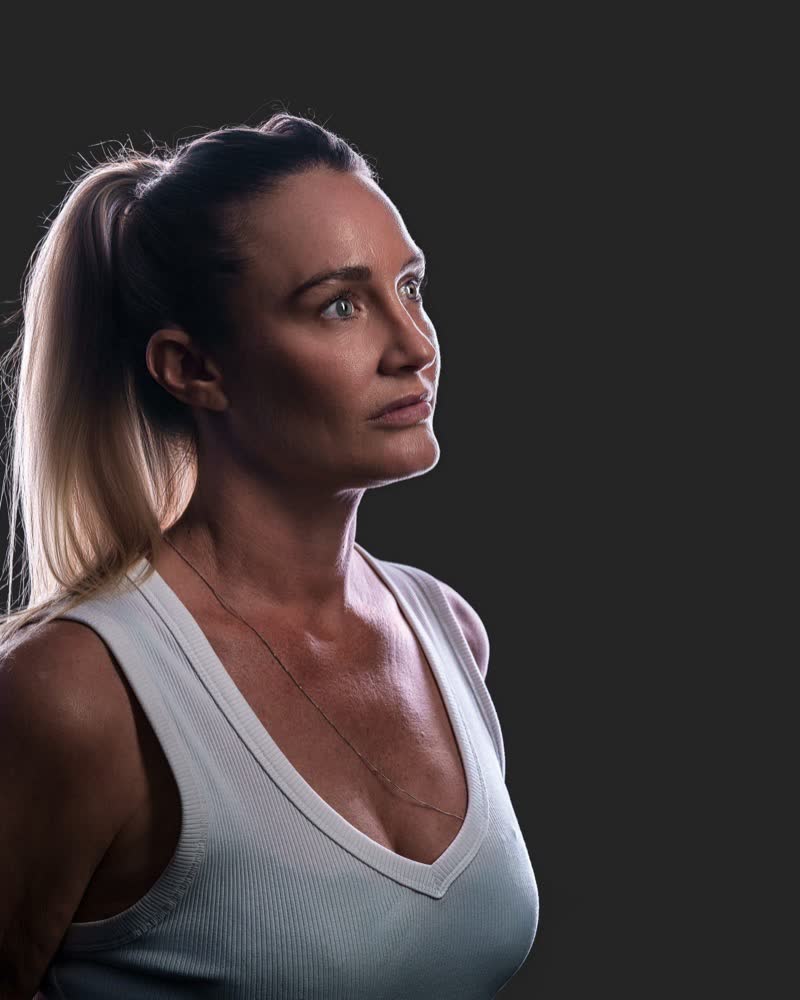Hockey ACT pathway athlete standing at three-quarter angle, backlit identity portrait