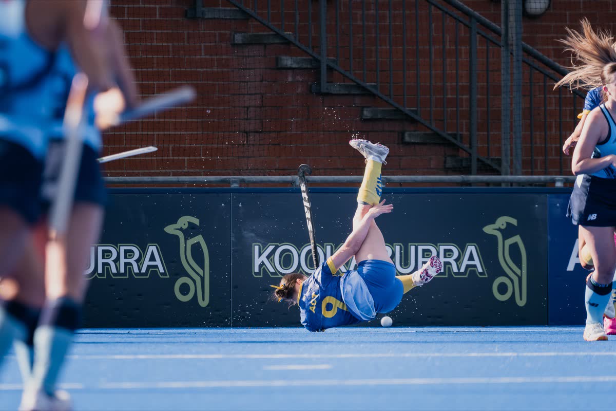 An ACT player dives full length in front of the boards at the Under 21 National Championships