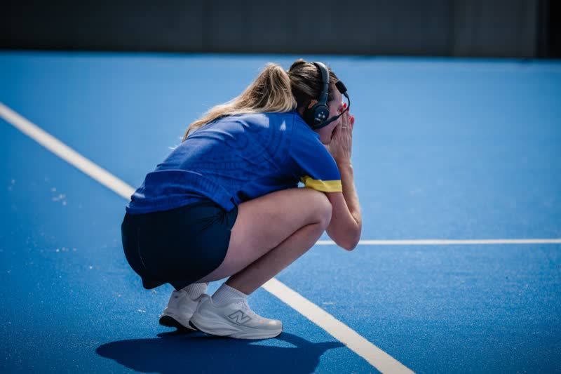 An ACT team member crouches on the turf with her head in her hands